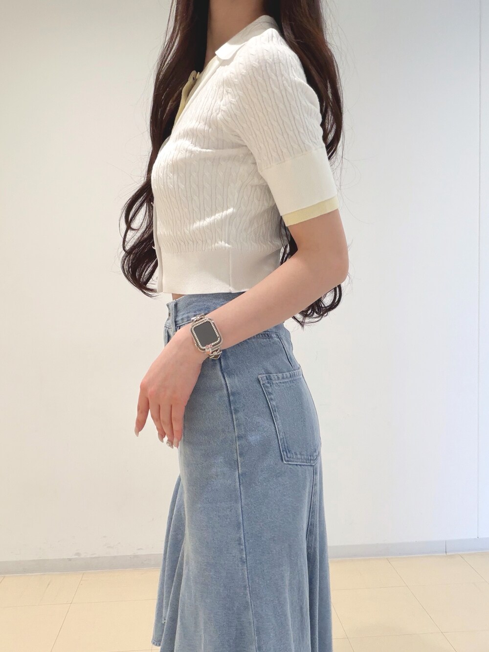 ホワイト系のニット/セーター、ブルー系のスカート、ブラウン系のハンドバッグを着用したレディースの春コーディネートの5枚目の写真