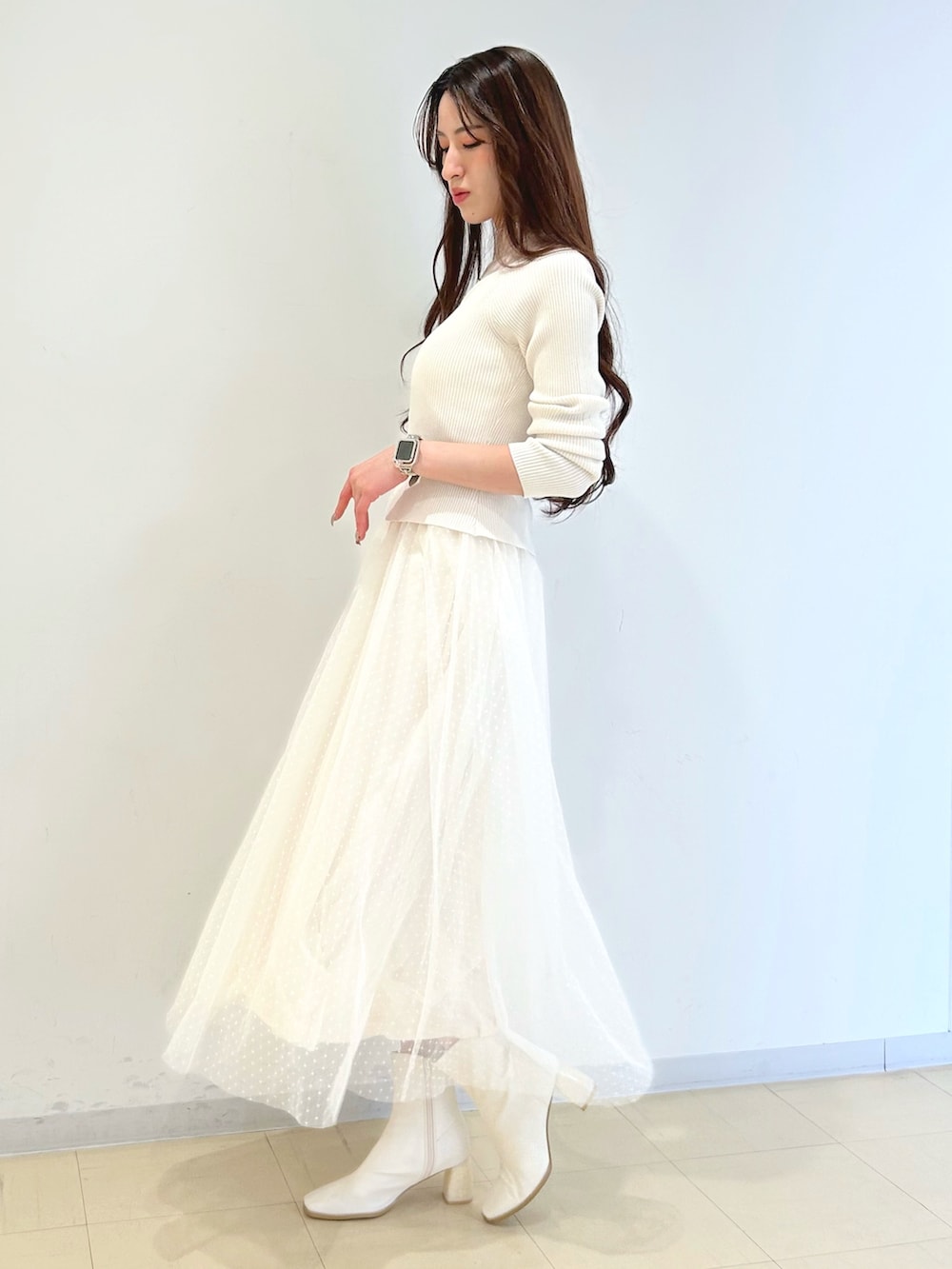 ホワイト系のワンピース、ピンク系のトレンチコート、ゴールド系のショルダーバッグを着用したレディースの冬コーディネートの2枚目の写真