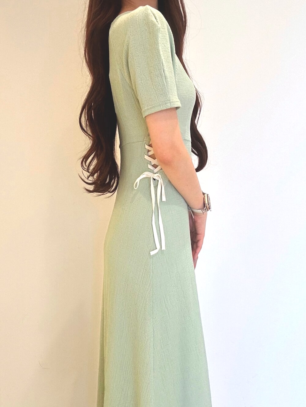 ホワイト系のサンダル、ホワイト系のショルダーバッグ、グリーン系のワンピースを着用したレディースの夏コーディネートの6枚目の写真