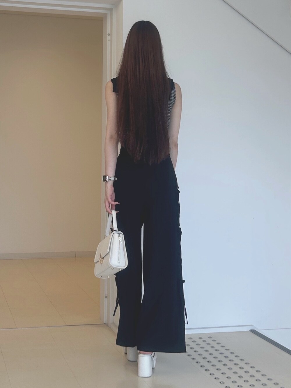 ブラック系のその他パンツ、ホワイト系のサンダル、ホワイト系のハンドバッグを着用したレディースの夏コーディネートの4枚目の写真