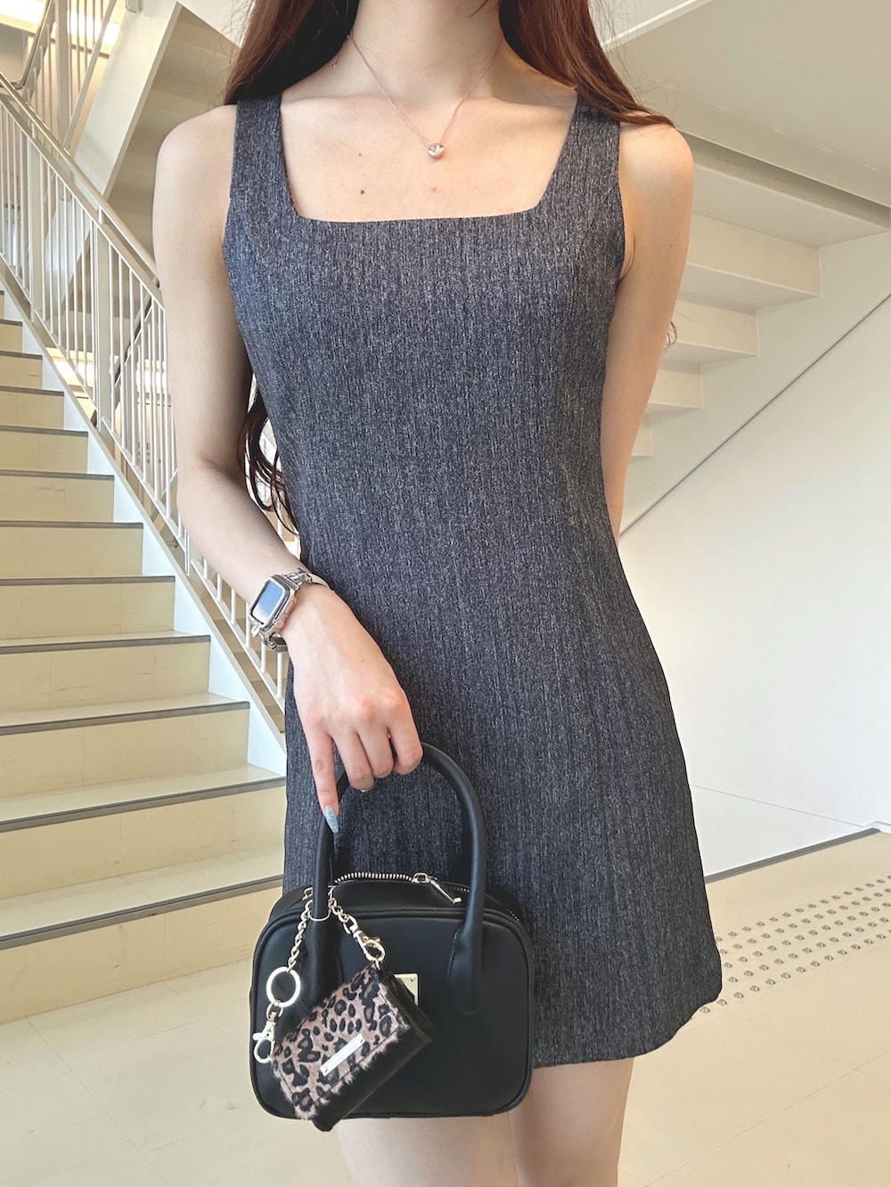 グレー系のワンピース、ブラック系のブーツ、ブラック系のハンドバッグを着用したレディースの夏コーディネートの5枚目の写真