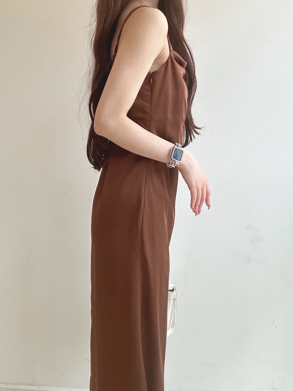 ブラウン系のワンピース、ホワイト系のハンドバッグ、ホワイト系のチューブトップを着用したレディースの夏コーディネートの6枚目の写真