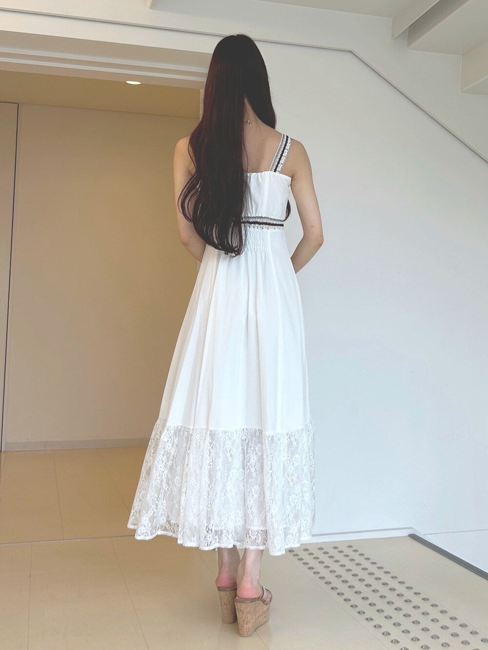 ホワイト系のワンピース、ブラウン系のサンダル、グリーン系のハンドバッグを着用したレディースの夏コーディネートの4枚目の写真