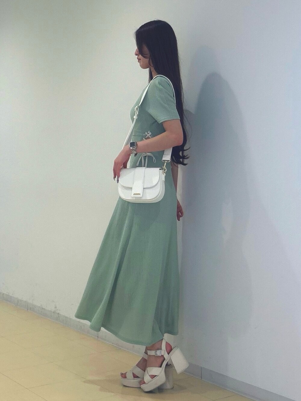 ホワイト系のサンダル、ホワイト系のショルダーバッグ、グリーン系のワンピースを着用したレディースの夏コーディネートの2枚目の写真