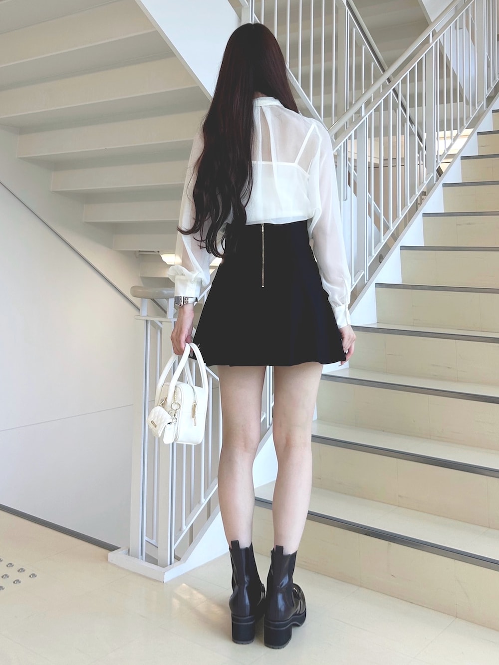 ホワイト系のシャツ/ブラウス、ブラック系のスカート、ブラウン系のブーツを着用したレディースの秋コーディネートの3枚目の写真