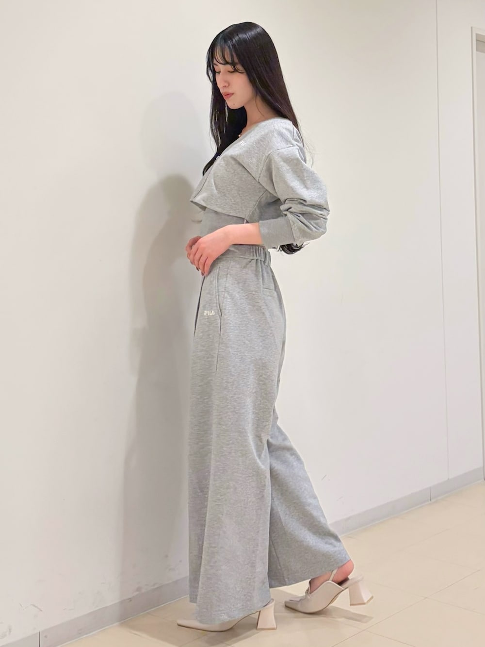 グレー系のその他パンツ、グレー系のTシャツ/カットソー、ホワイト系のパンプスを着用したレディースの冬コーディネートの2枚目の写真