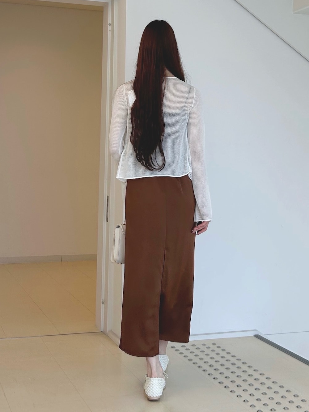 ブラウン系のワンピース、ホワイト系のチューブトップ、ホワイト系のハンドバッグを着用したレディースの夏コーディネートの4枚目の写真