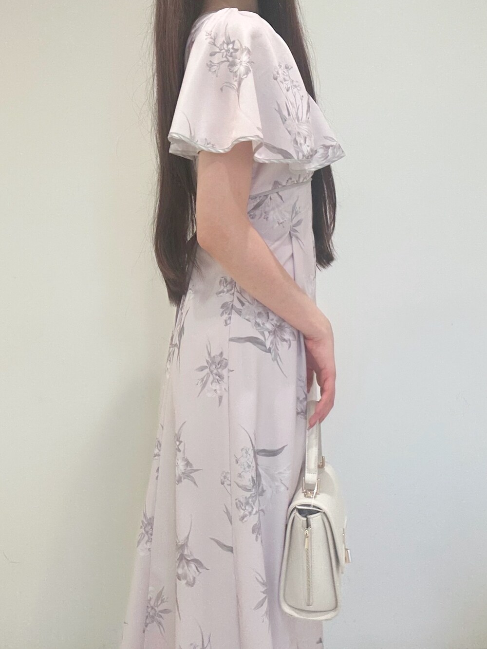 ピンク系のワンピース、ホワイト系のハンドバッグ、ホワイト系のパンプスを着用したレディースの夏コーディネートの6枚目の写真