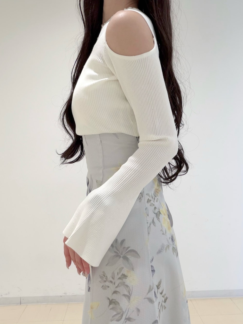 ホワイト系のニット/セーター、ブラウン系のハンドバッグ、グリーン系のスカートを着用したレディースの冬コーディネートの5枚目の写真