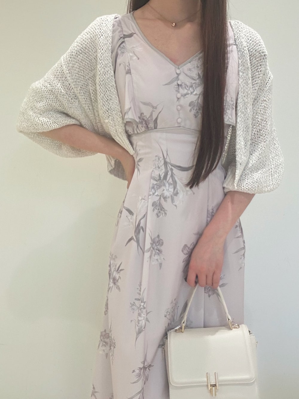 ピンク系のワンピース、ホワイト系のパンプス、ホワイト系のハンドバッグを着用したレディースの夏コーディネートの5枚目の写真