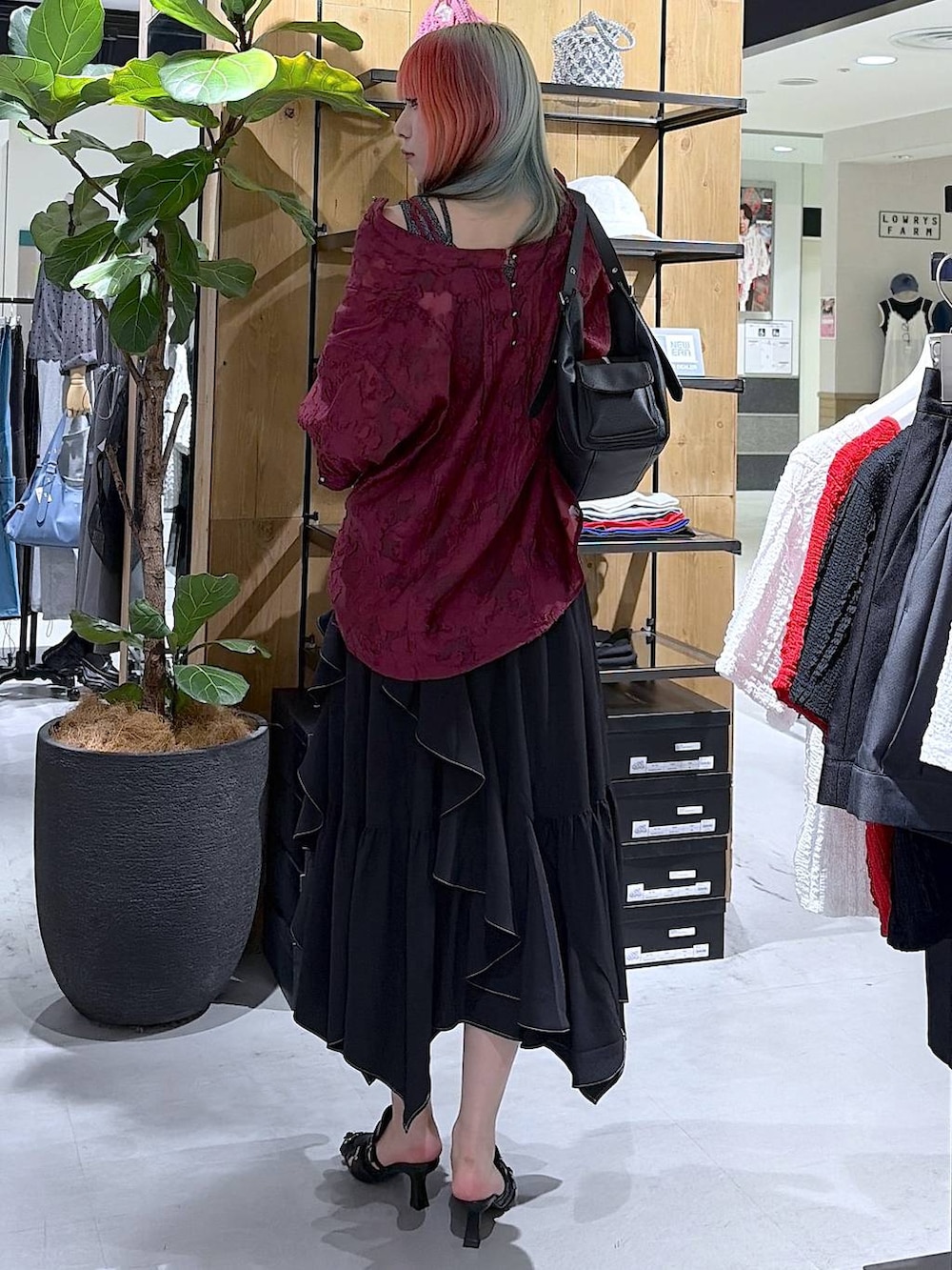 ブラック系のスカート、ブラック系のサンダル、ブラック系のハンドバッグを着用したレディースの夏コーディネートの4枚目の写真
