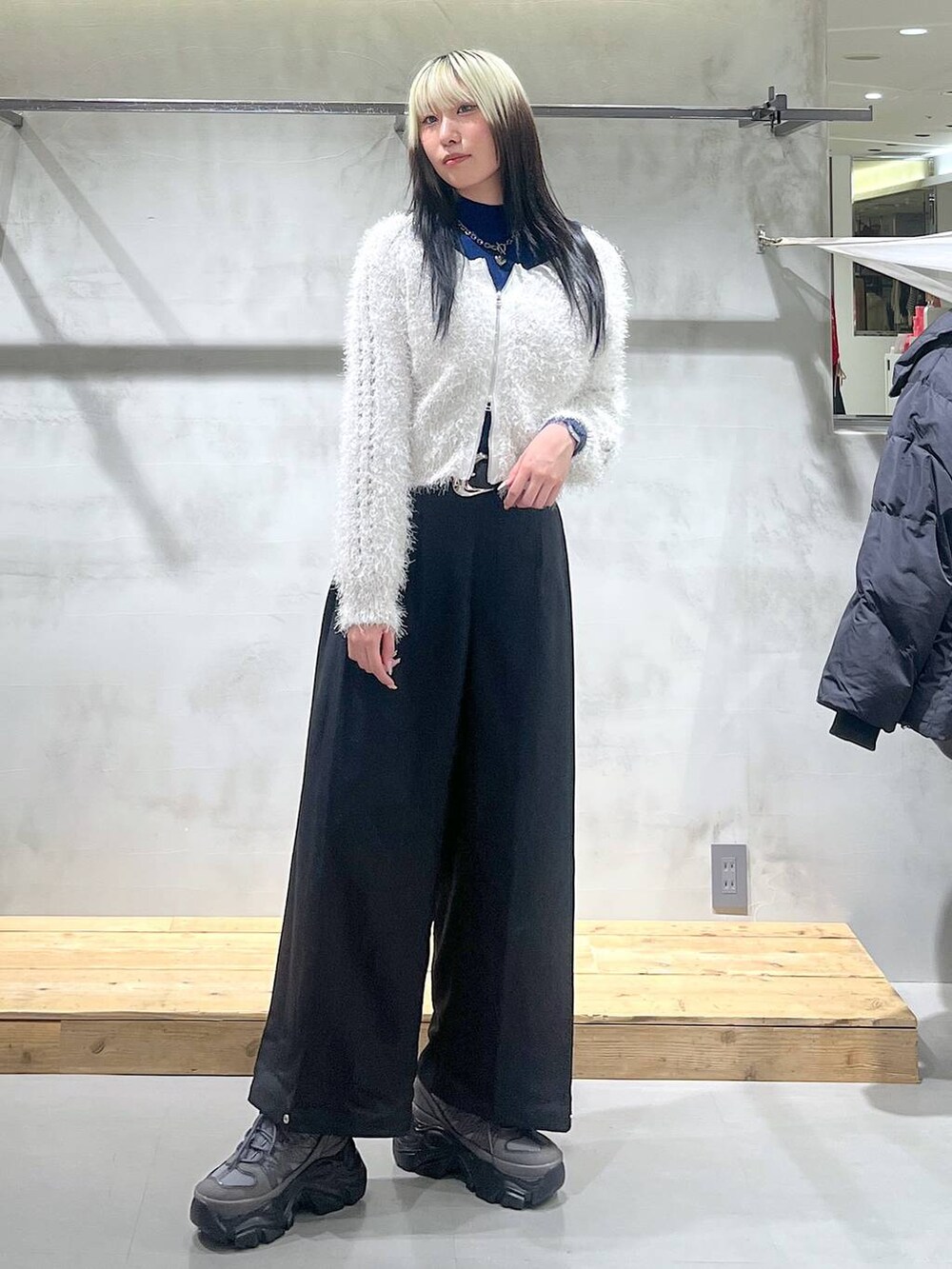 グレー系のスニーカー、ホワイト系のカーディガン/ボレロ、ブラック系のスラックスを着用したレディースの秋コーディネートの3枚目の写真