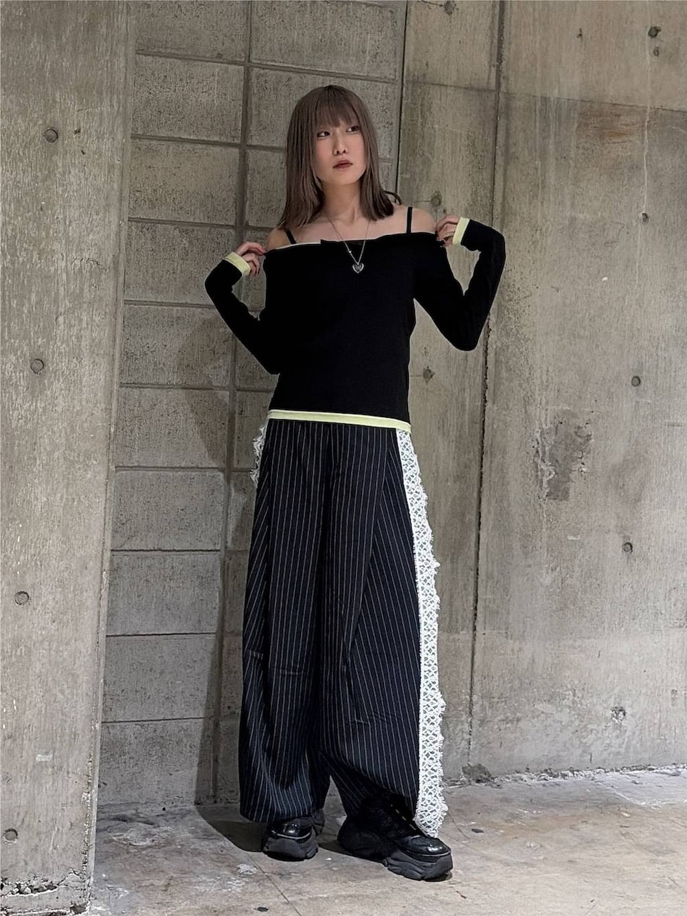 ブラック系のTシャツ/カットソー、ブラック系のスニーカー、ブルー系のスラックスを着用したレディースの秋コーディネートの4枚目の写真
