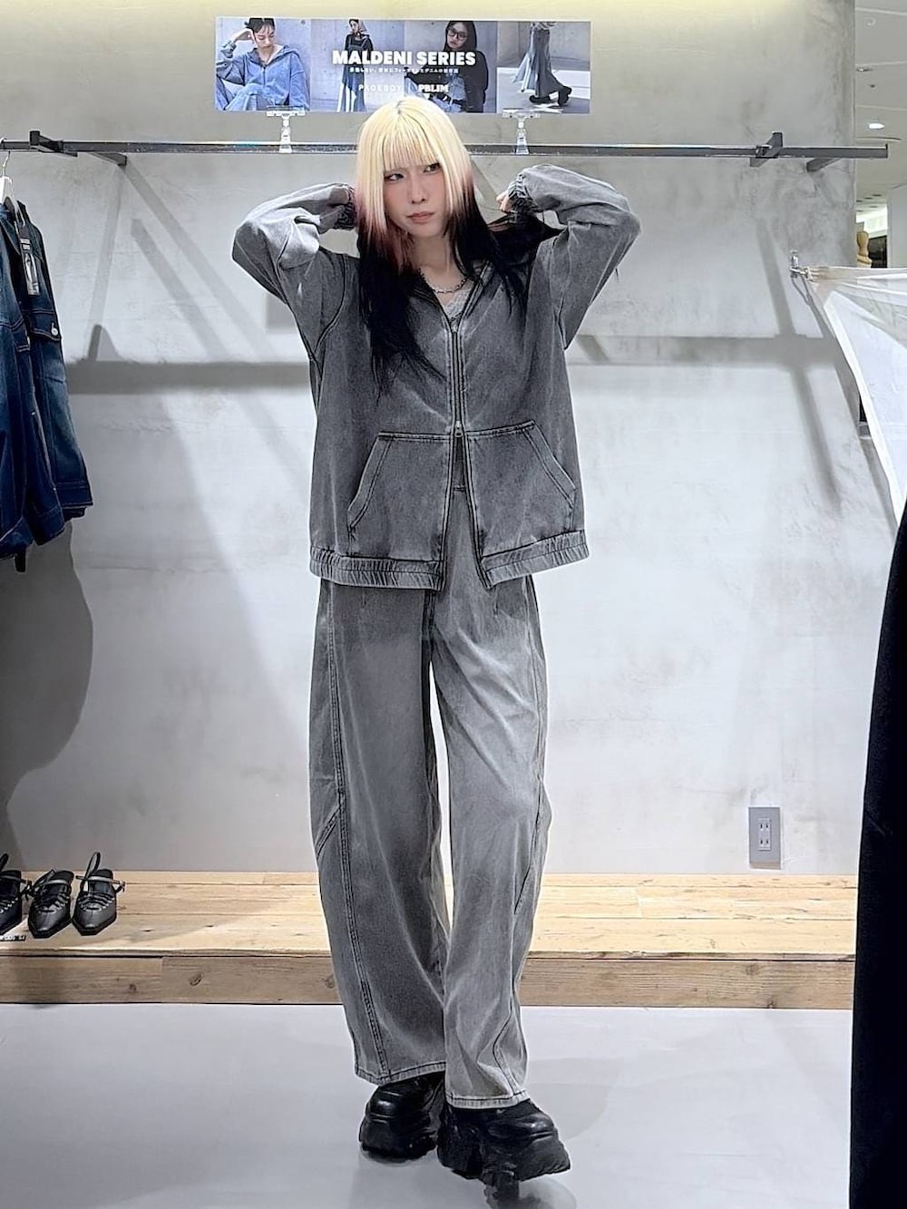 ブラック系のブーツ、グレー系のキャミソール、ブラック系のデニムパンツを着用したレディースの春コーディネートの2枚目の写真