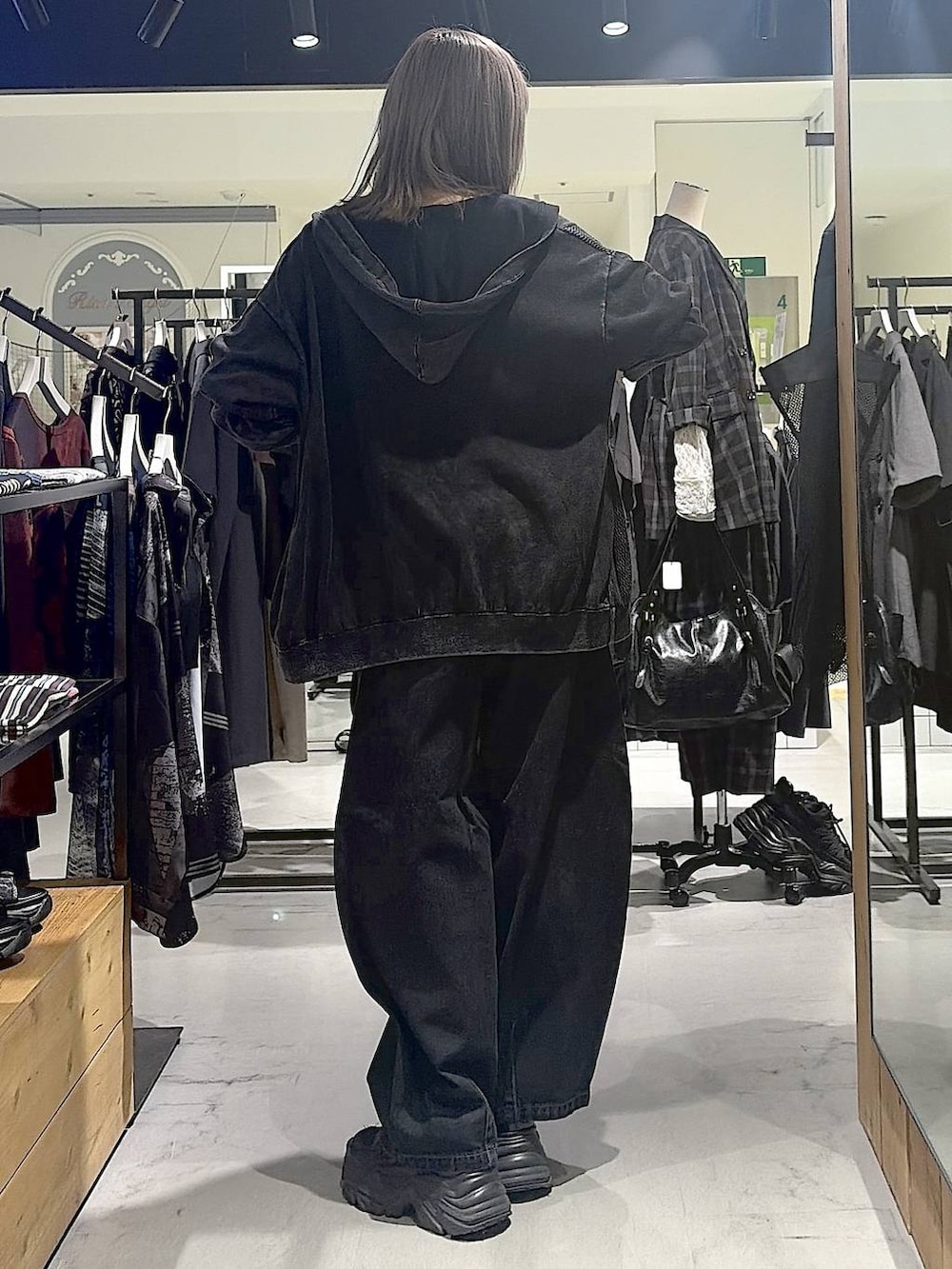 グレー系のパーカー、ブラック系のデニムパンツ、ブラック系のスニーカーを着用したレディースの秋コーディネートの9枚目の写真