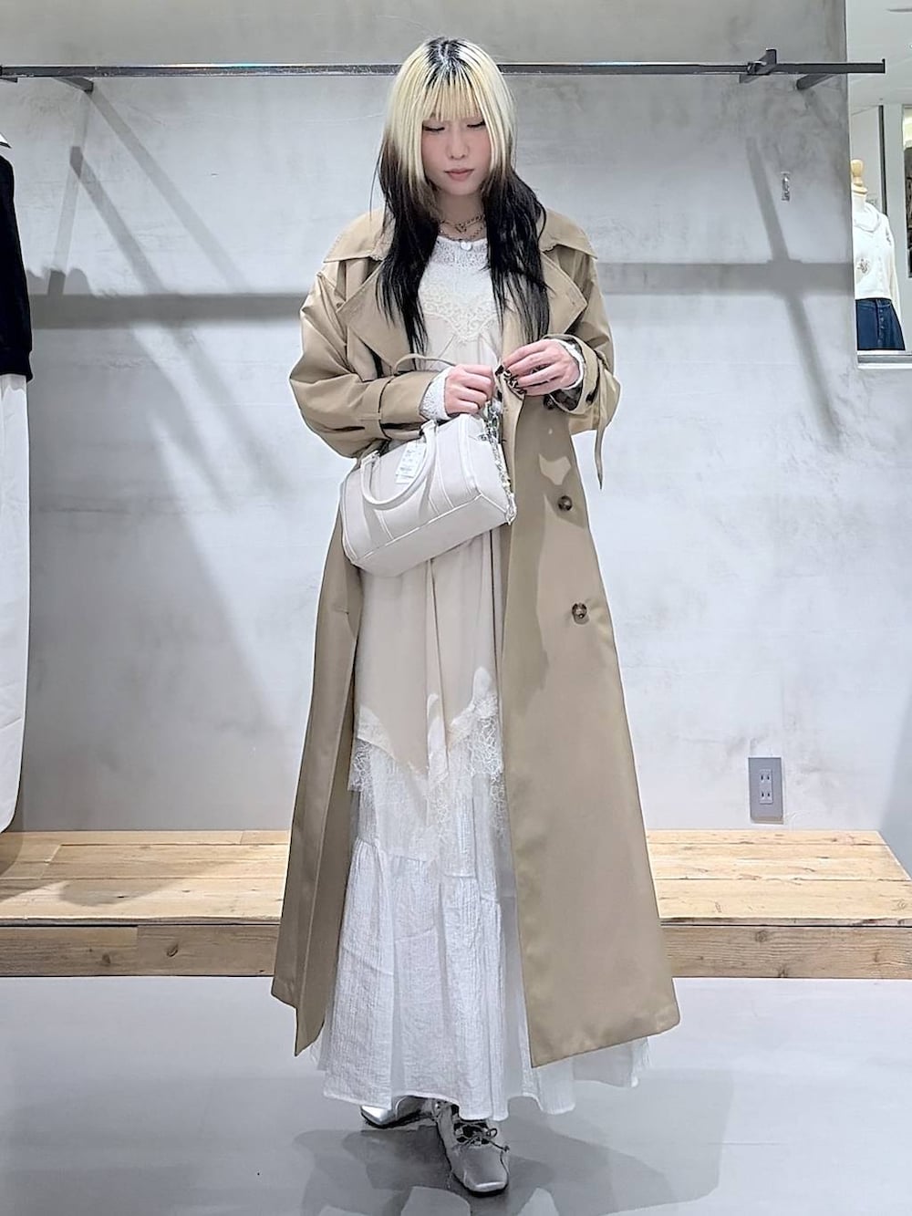 ベージュ系のトレンチコート、ホワイト系のボストンバッグ、シルバー系のスニーカーを着用したレディースの春コーディネートの5枚目の写真