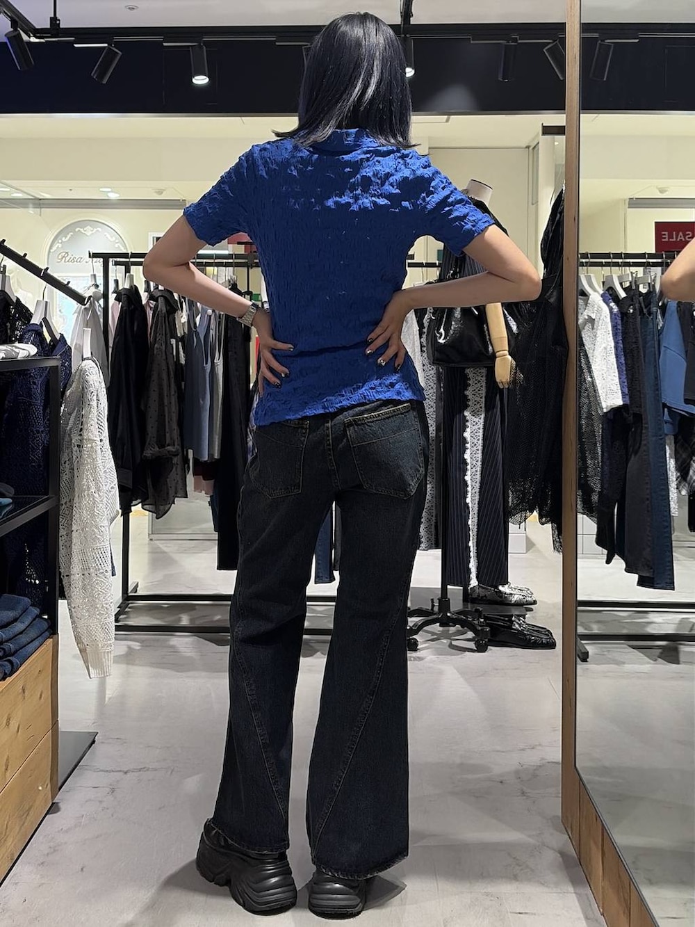 ブラック系のスニーカー、ブルー系のデニムパンツ、ブルー系のシャツ/ブラウスを着用したレディースの夏コーディネートの9枚目の写真
