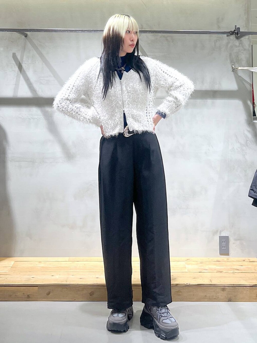 グレー系のスニーカー、ホワイト系のカーディガン/ボレロ、ブラック系のスラックスを着用したレディースの秋コーディネートの4枚目の写真