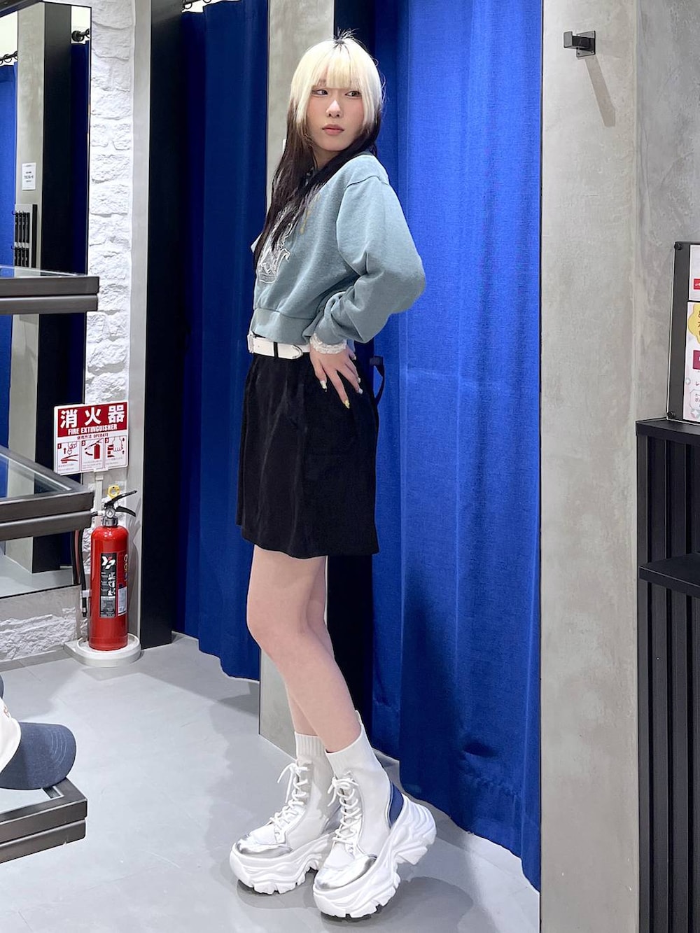 ホワイト系のブーツ、グリーン系のスウェット、ブラック系のスカートを着用したレディースの冬コーディネートの3枚目の写真