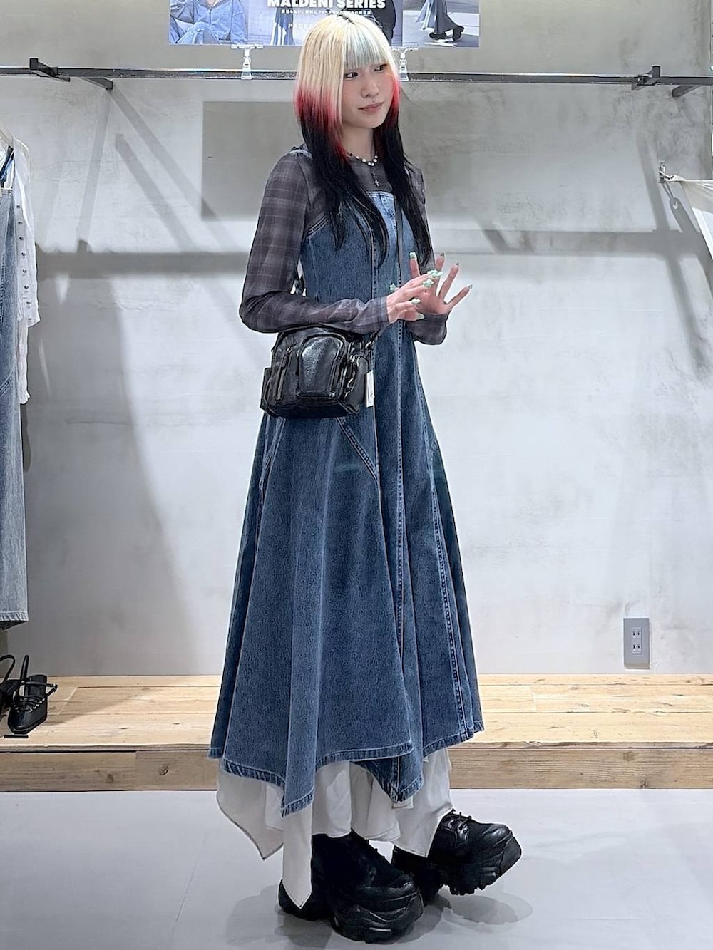 ブラック系のブーツ、ベージュ系のスカート、ブラック系のショルダーバッグを着用したレディースの春コーディネートの4枚目の写真