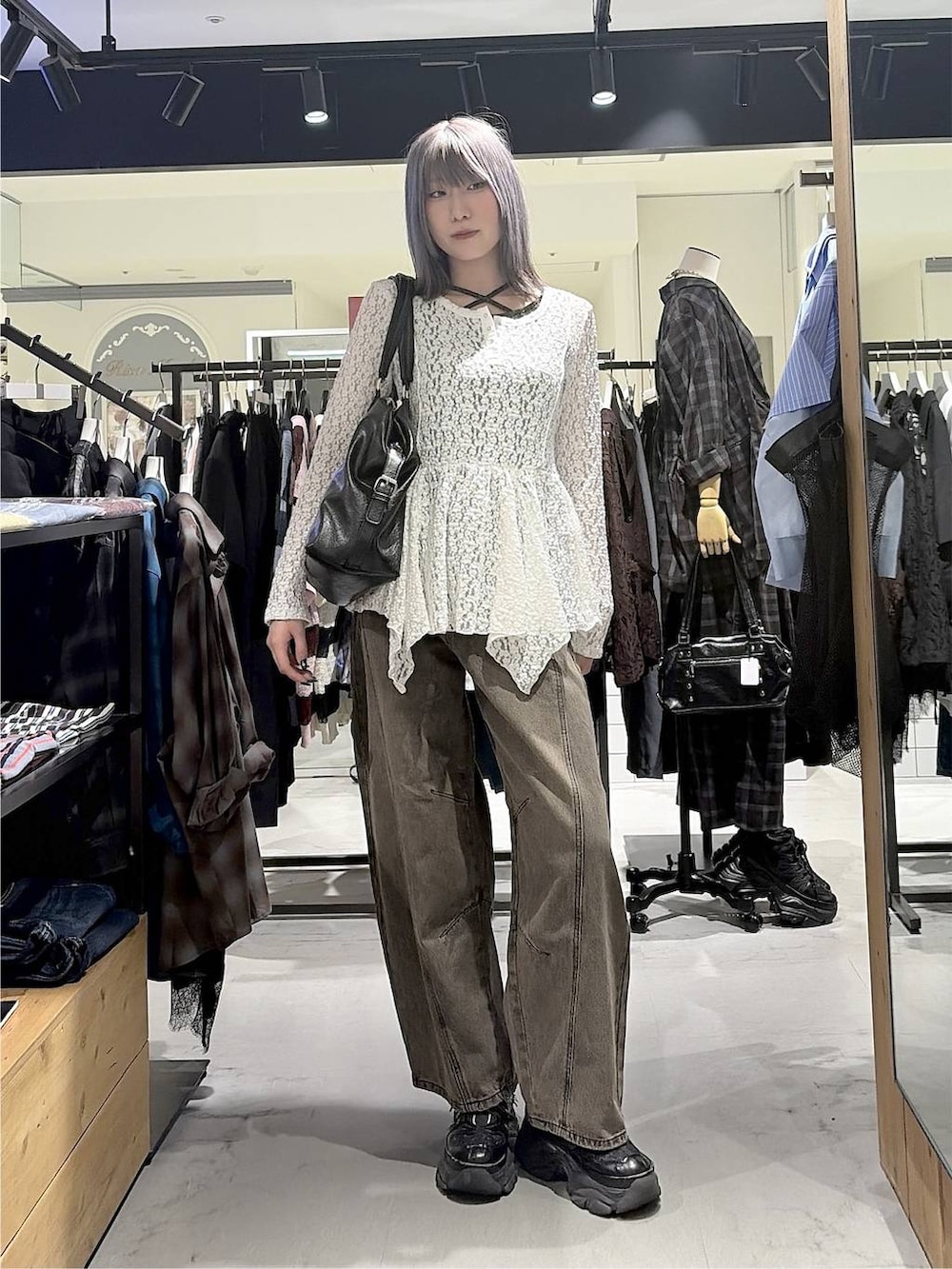 ブラック系のボストンバッグ、ブラウン系のデニムパンツ、ブラック系のスニーカーを着用したレディースの秋コーディネートの3枚目の写真