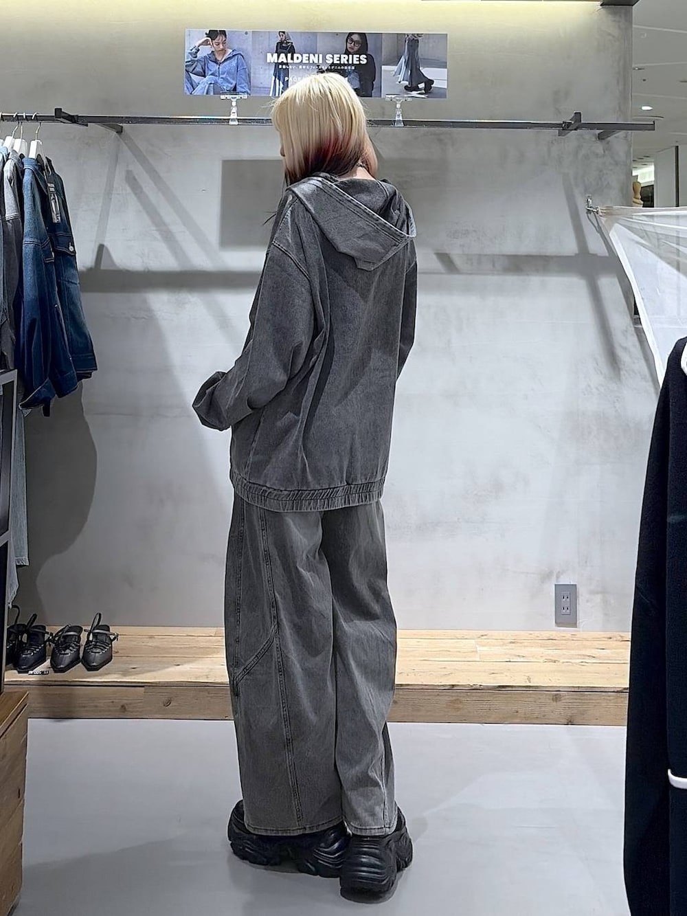 ブラック系のブーツ、グレー系のキャミソール、ブラック系のデニムパンツを着用したレディースの春コーディネートの4枚目の写真