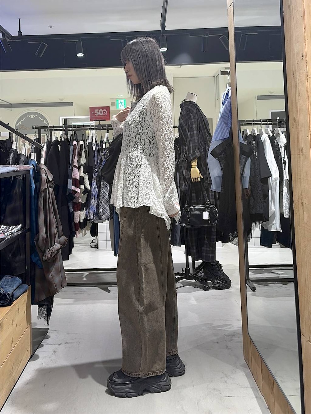 ブラック系のボストンバッグ、ブラウン系のデニムパンツ、ブラック系のスニーカーを着用したレディースの秋コーディネートの8枚目の写真