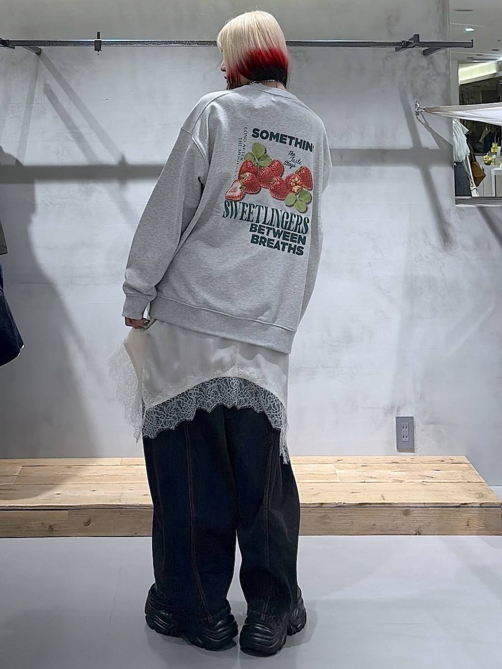 ブラック系のブーツ、ブラック系のデニムパンツ、ホワイト系のチュニックを着用したレディースの冬コーディネートの6枚目の写真