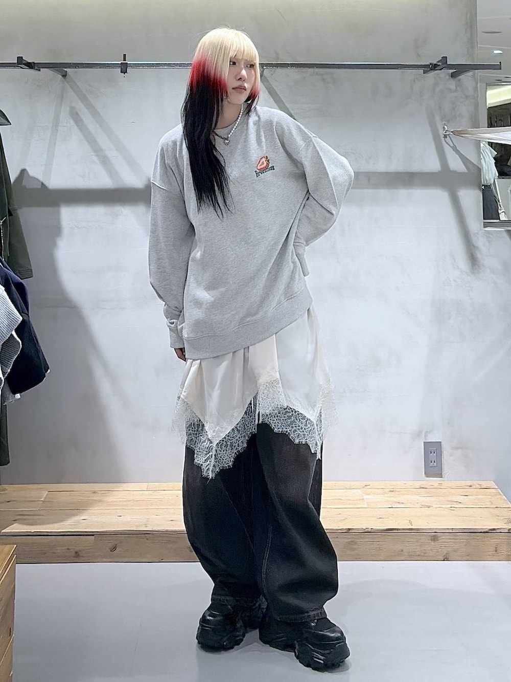 ブラック系のブーツ、ブラック系のデニムパンツ、ホワイト系のチュニックを着用したレディースの冬コーディネートの5枚目の写真