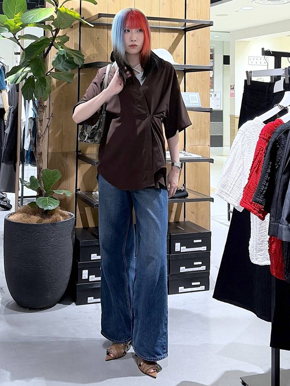 ブルー系のデニムパンツ、イエロー系のサンダル、その他のトートバッグを着用したレディースの夏コーディネートの2枚目の写真