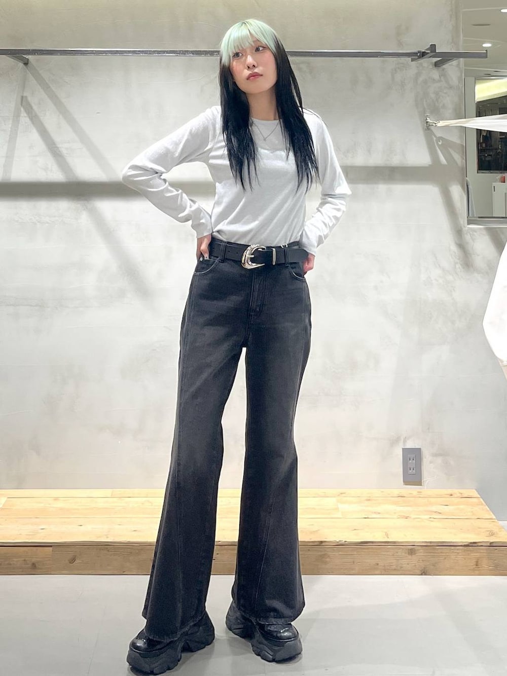 ブラック系のスニーカー、ホワイト系のTシャツ/カットソー、ブラック系のデニムパンツを着用したレディースの冬コーディネートの2枚目の写真