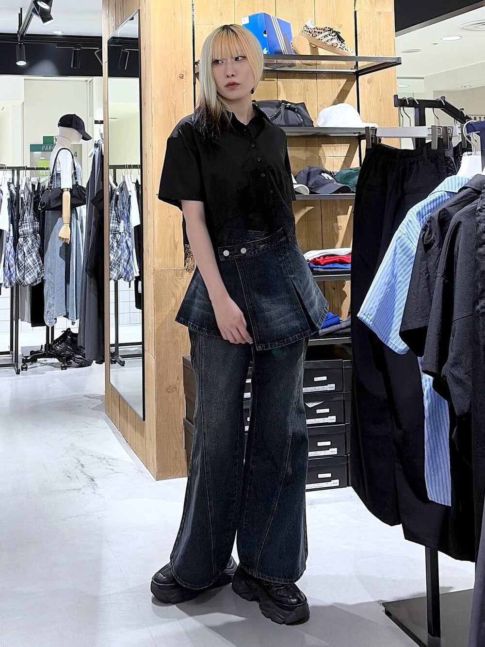 ブラック系のスニーカー、ブルー系のデニムパンツ、ブラック系のシャツ/ブラウスを着用したレディースの夏コーディネートの2枚目の写真