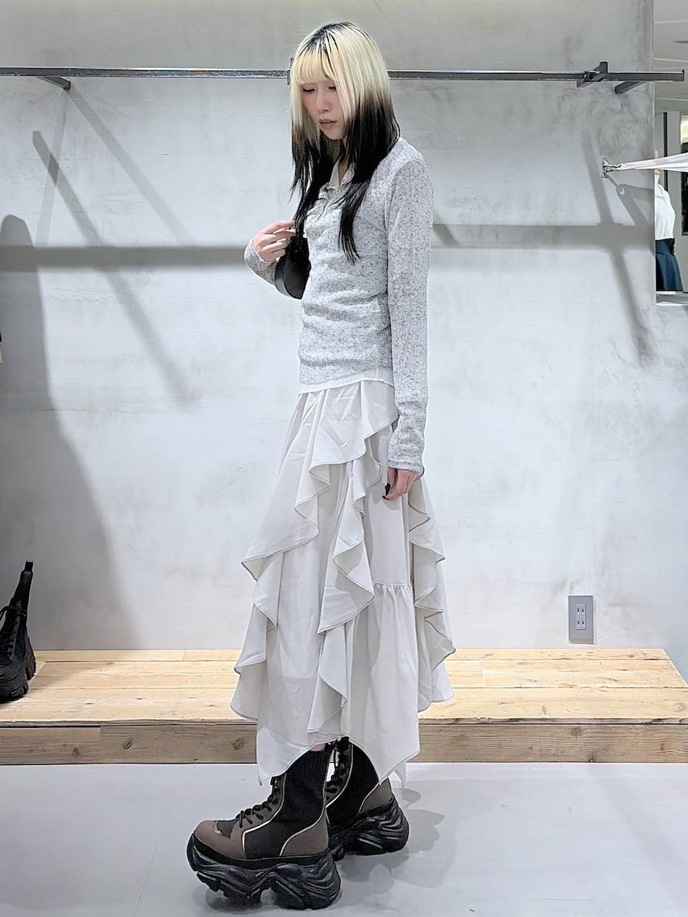 ブラウン系のブーツ、ベージュ系のスカート、ブラウン系のハンドバッグを着用したレディースの春コーディネートの4枚目の写真