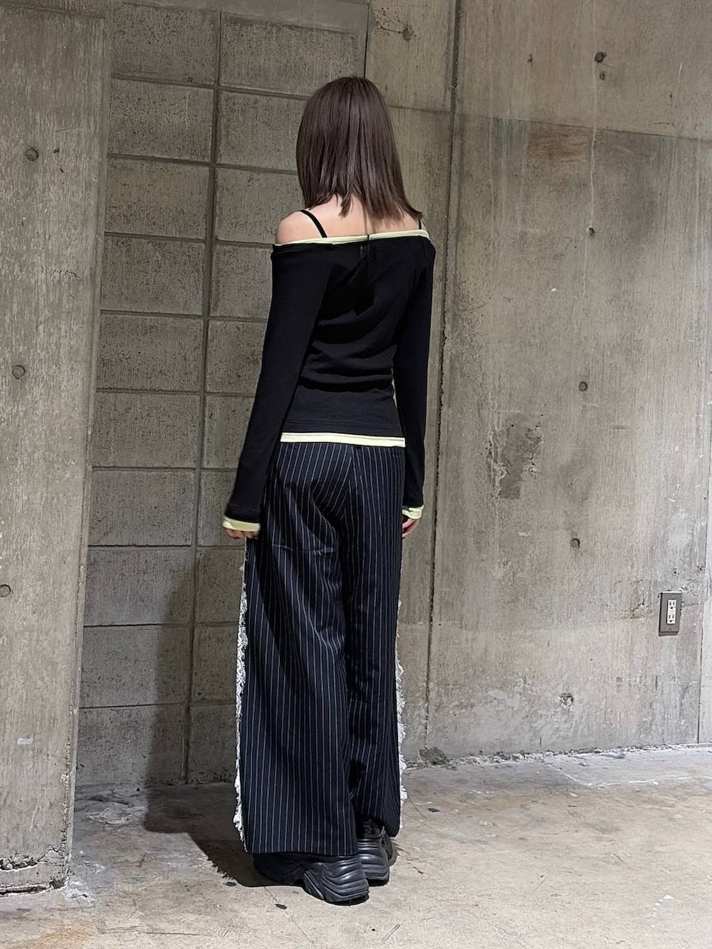 ブラック系のTシャツ/カットソー、ブラック系のスニーカー、ブルー系のスラックスを着用したレディースの秋コーディネートの9枚目の写真