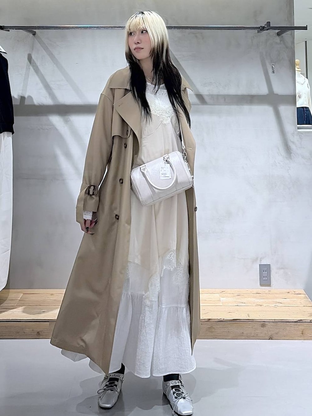 ベージュ系のトレンチコート、ホワイト系のボストンバッグ、シルバー系のスニーカーを着用したレディースの春コーディネートの7枚目の写真