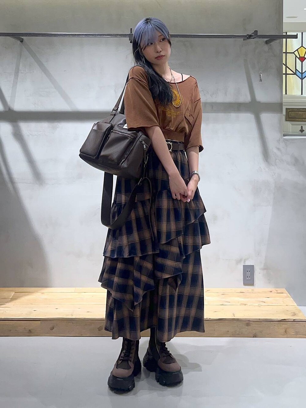 ブラウン系のブーツ、ブラウン系のボストンバッグ、ブラウン系のTシャツ/カットソーを着用したレディースの夏コーディネートの2枚目の写真