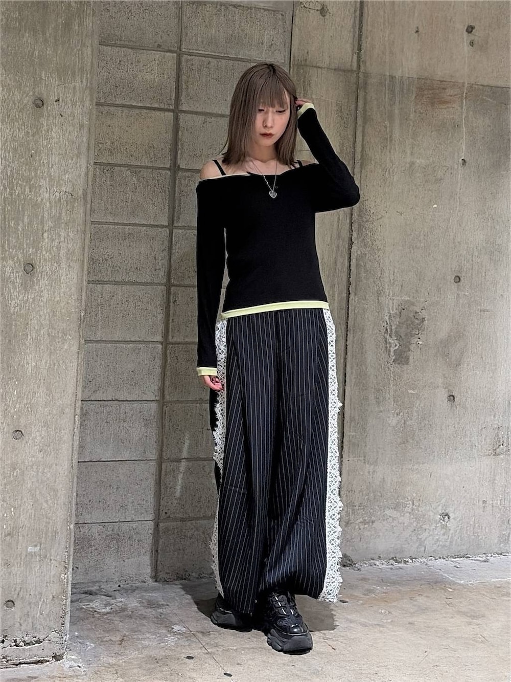 ブラック系のTシャツ/カットソー、ブラック系のスニーカー、ブルー系のスラックスを着用したレディースの秋コーディネートの7枚目の写真