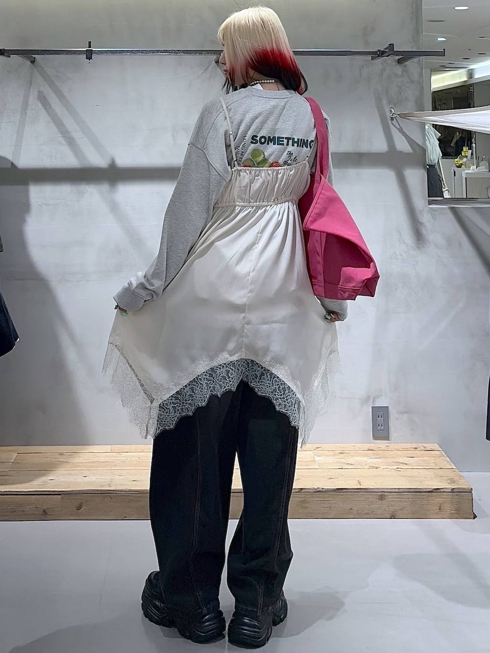 ブラック系のブーツ、ブラック系のデニムパンツ、ホワイト系のチュニックを着用したレディースの冬コーディネートの4枚目の写真