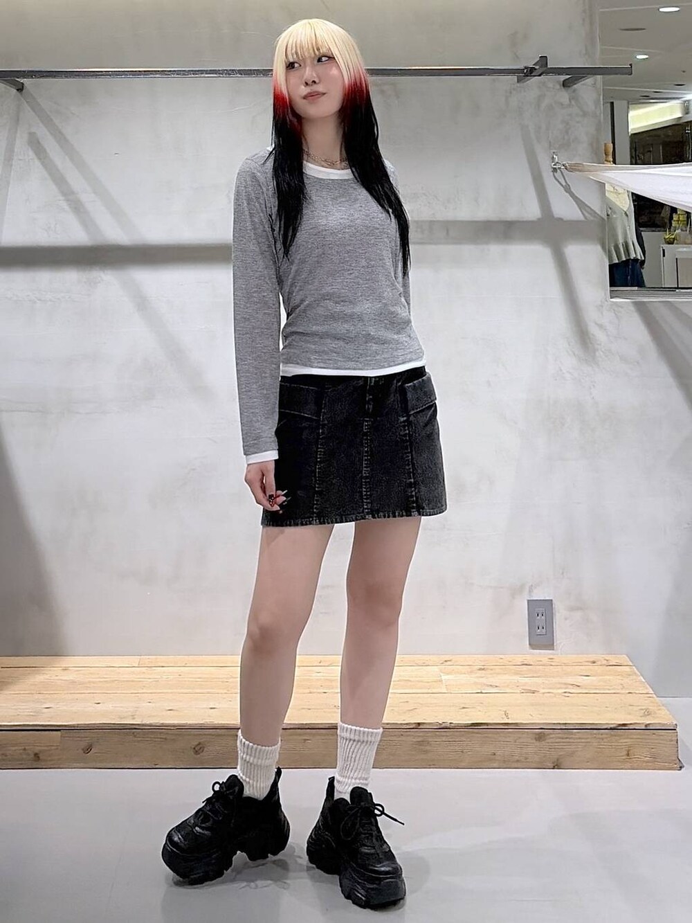 ブラック系のスニーカー、グレー系のTシャツ/カットソー、ブラック系のスカートを着用したレディースの春コーディネートの2枚目の写真