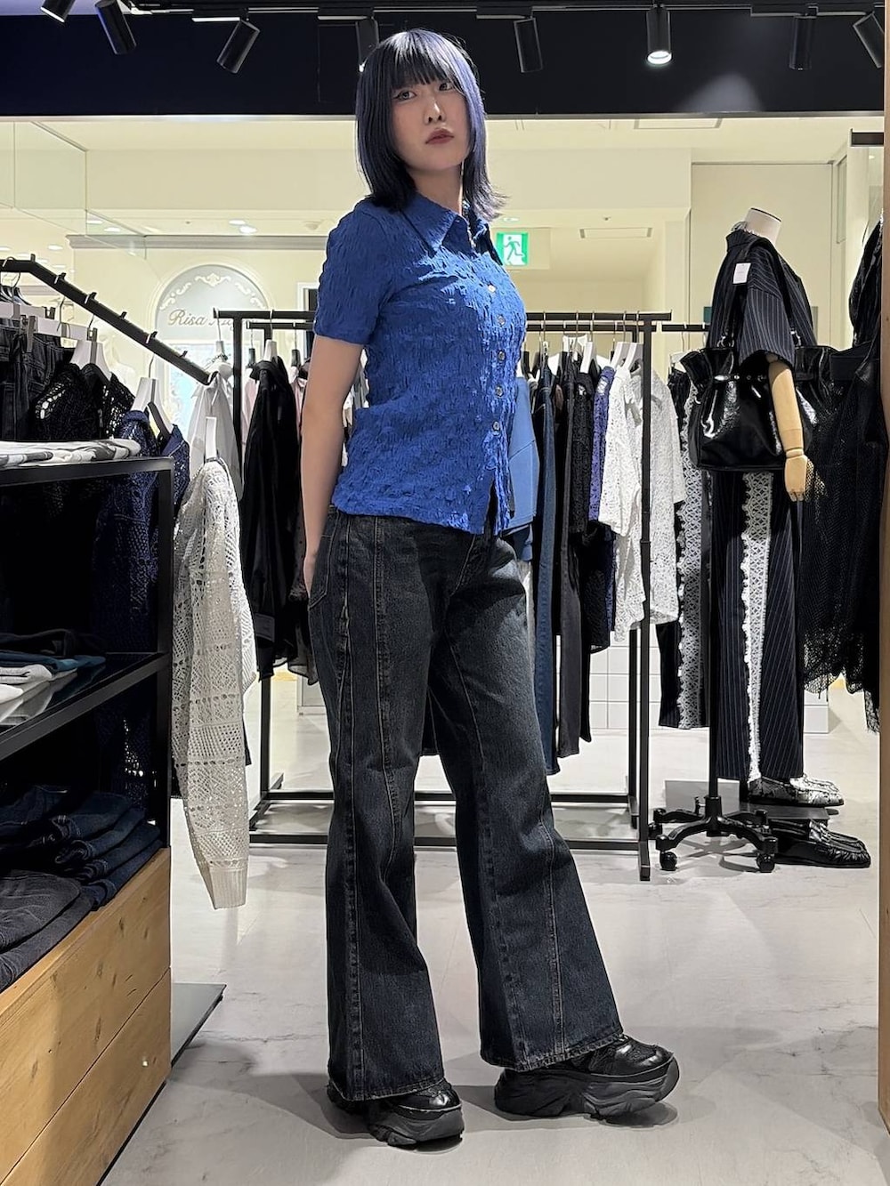 ブラック系のスニーカー、ブルー系のデニムパンツ、ブルー系のシャツ/ブラウスを着用したレディースの夏コーディネートの4枚目の写真