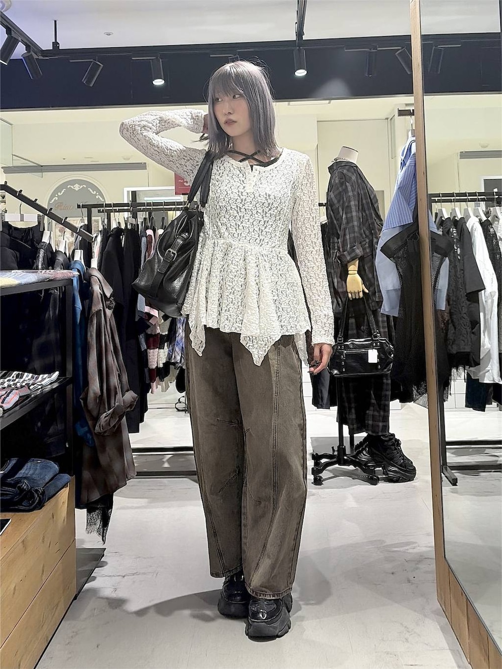 ブラック系のボストンバッグ、ブラウン系のデニムパンツ、ブラック系のスニーカーを着用したレディースの秋コーディネートの2枚目の写真