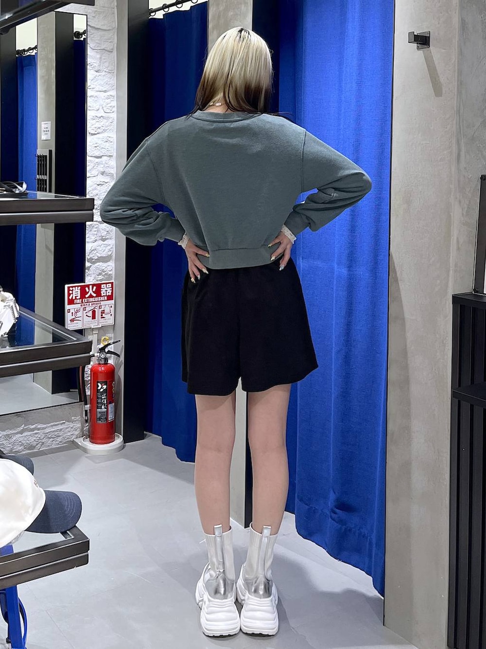 ホワイト系のブーツ、グリーン系のスウェット、ブラック系のスカートを着用したレディースの冬コーディネートの6枚目の写真