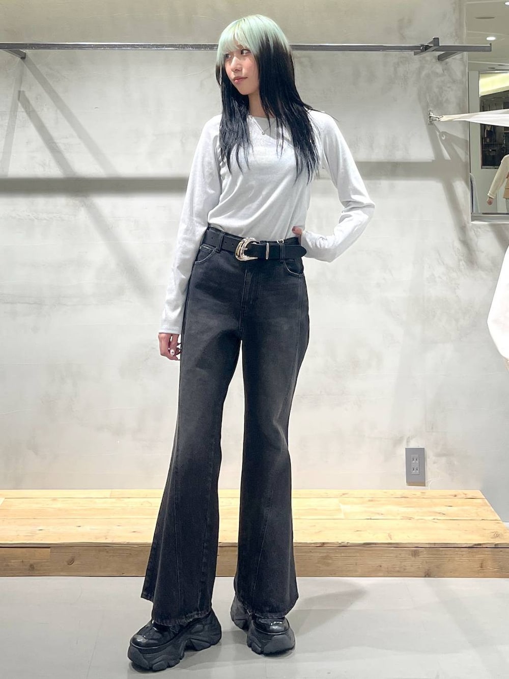 ブラック系のスニーカー、ホワイト系のTシャツ/カットソー、ブラック系のデニムパンツを着用したレディースの冬コーディネートの4枚目の写真