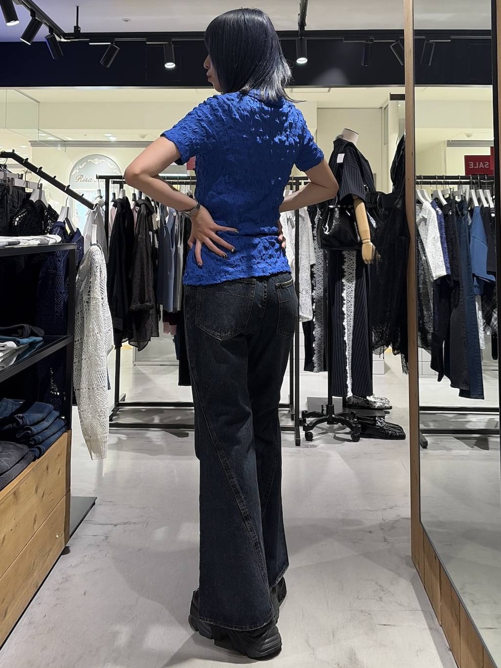 ブラック系のスニーカー、ブルー系のデニムパンツ、ブルー系のシャツ/ブラウスを着用したレディースの夏コーディネートの8枚目の写真