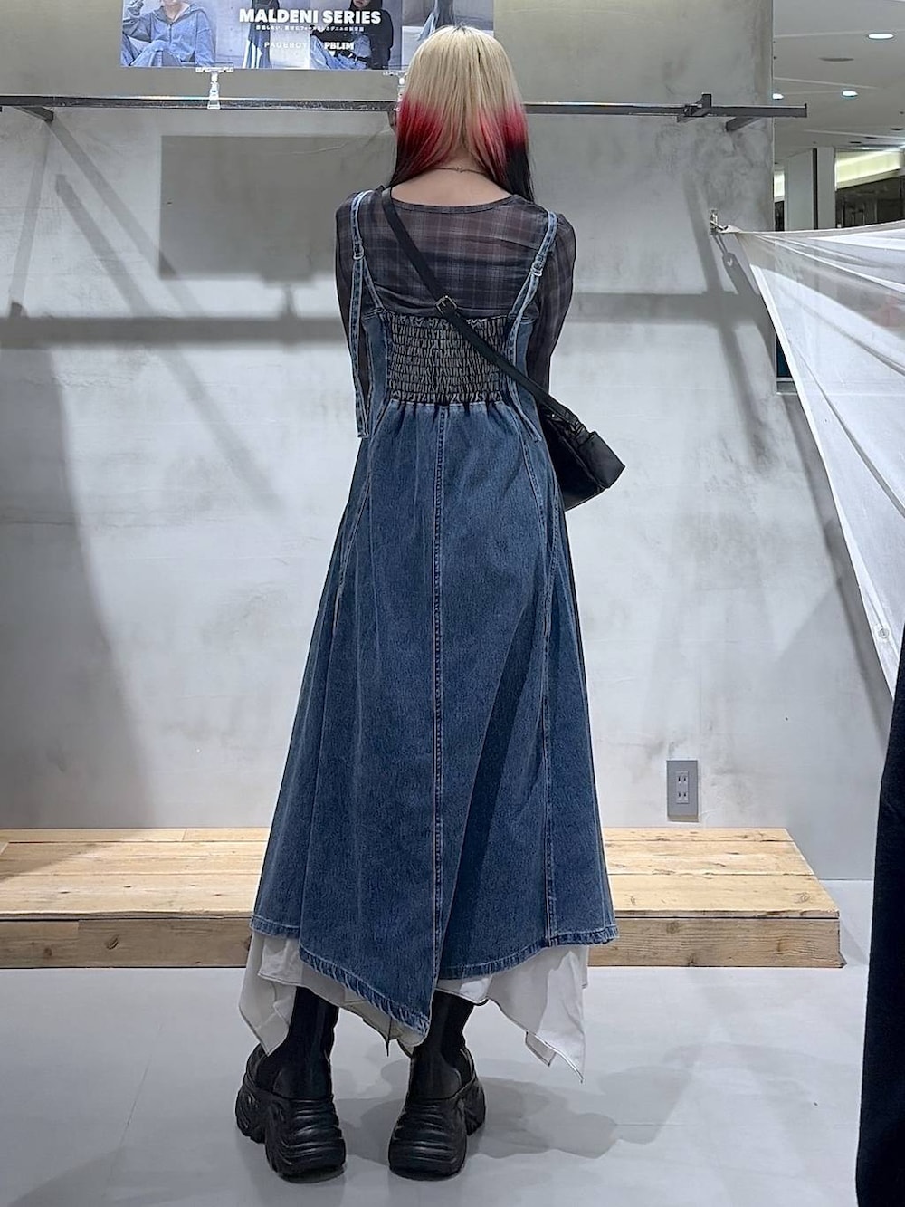 ブラック系のブーツ、ベージュ系のスカート、ブラック系のショルダーバッグを着用したレディースの春コーディネートの9枚目の写真