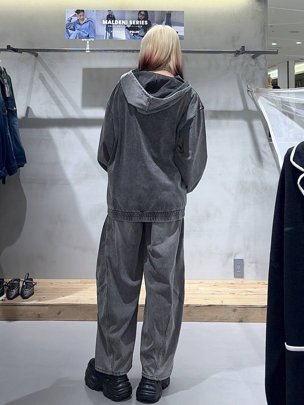 ブラック系のブーツ、グレー系のキャミソール、ブラック系のデニムパンツを着用したレディースの春コーディネートの6枚目の写真