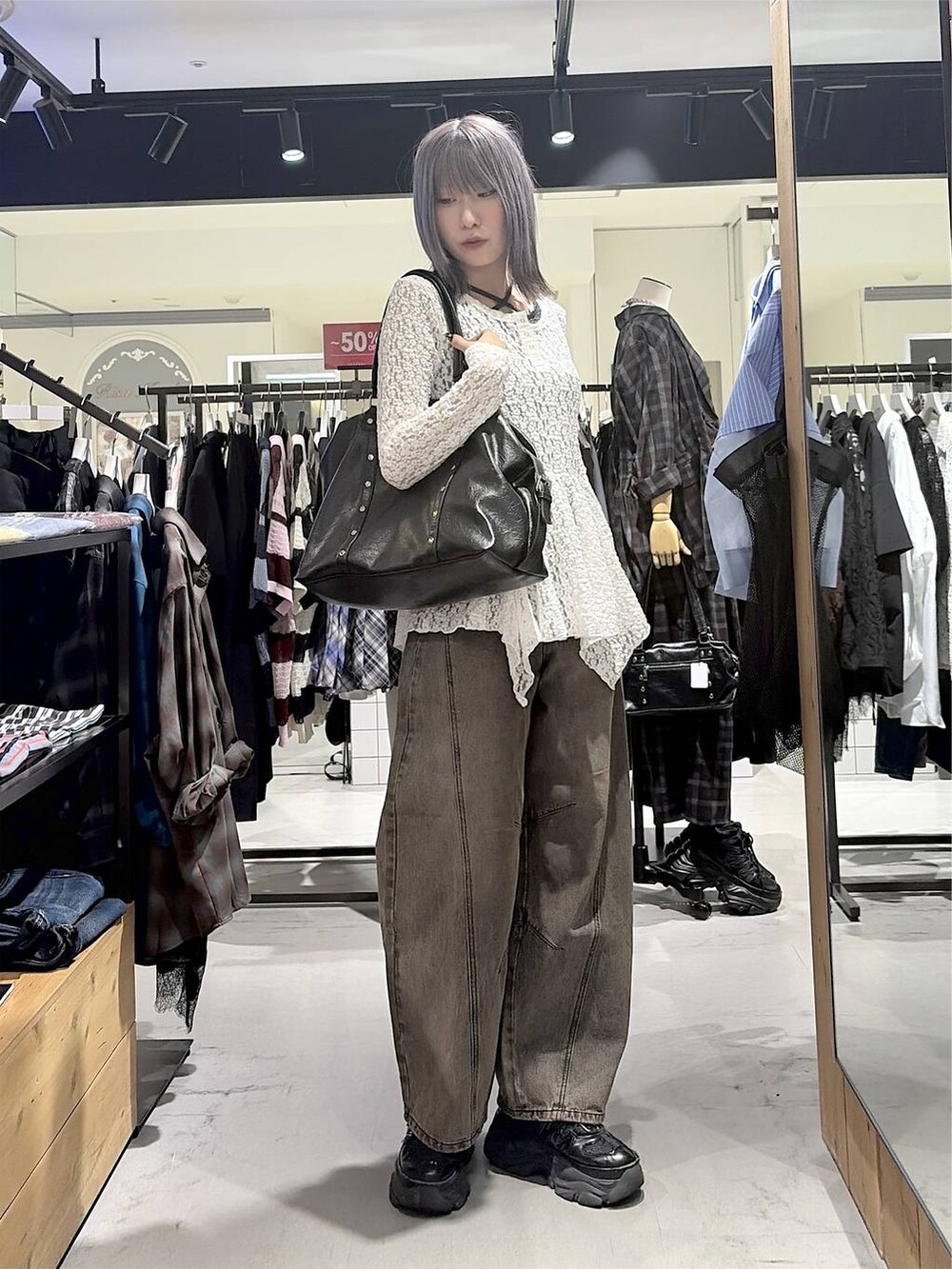 ブラック系のボストンバッグ、ブラウン系のデニムパンツ、ブラック系のスニーカーを着用したレディースの秋コーディネートの7枚目の写真