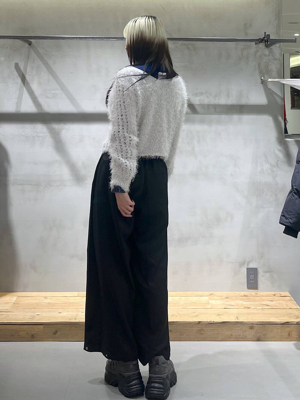 グレー系のスニーカー、ホワイト系のカーディガン/ボレロ、ブラック系のスラックスを着用したレディースの秋コーディネートの5枚目の写真