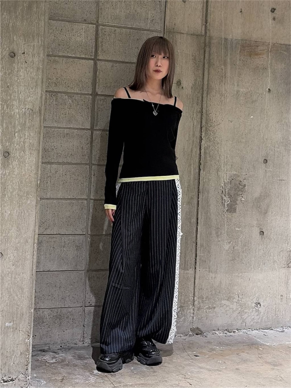 ブラック系のTシャツ/カットソー、ブラック系のスニーカー、ブルー系のスラックスを着用したレディースの秋コーディネートの3枚目の写真