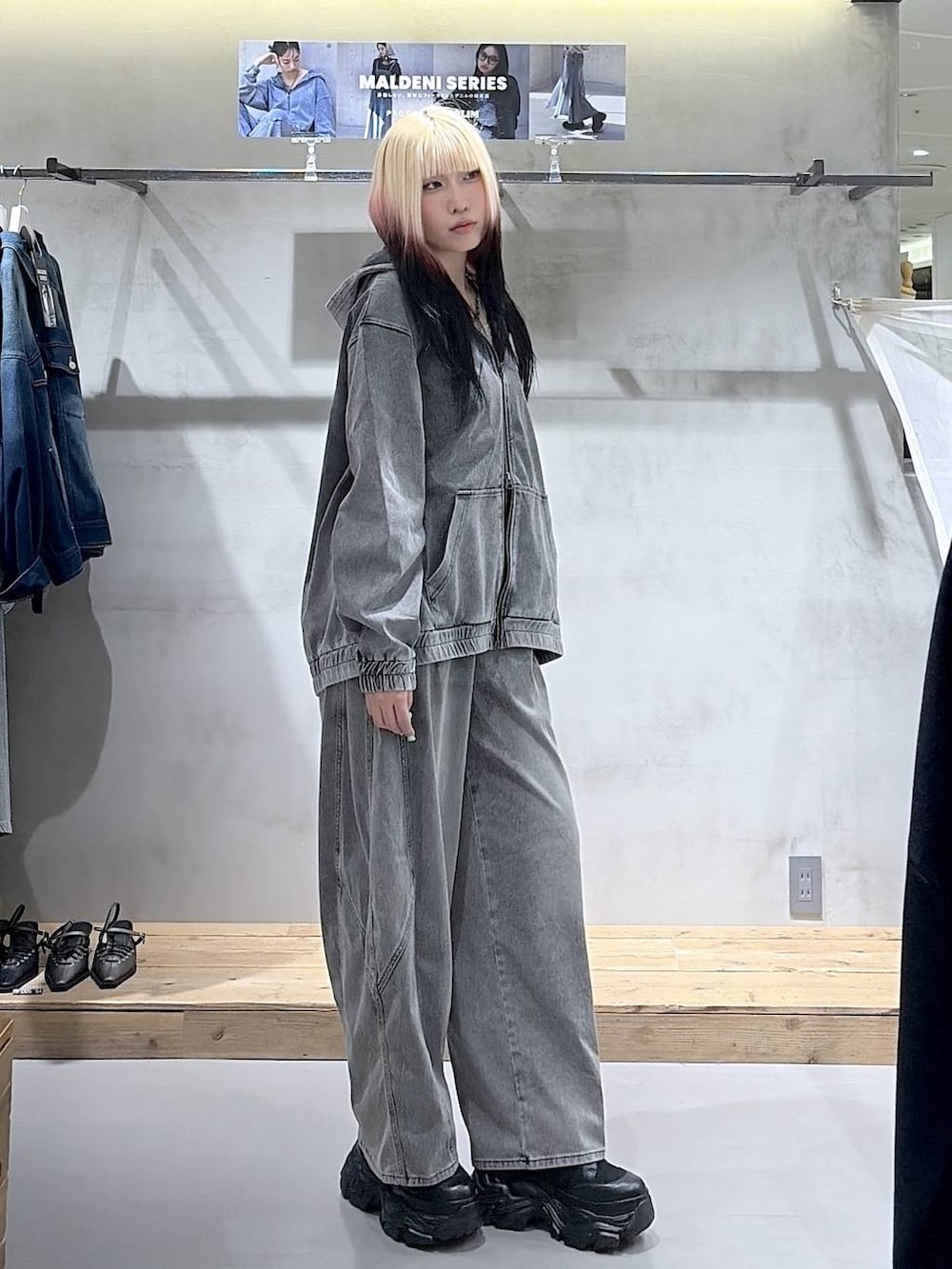 ブラック系のブーツ、グレー系のキャミソール、ブラック系のデニムパンツを着用したレディースの春コーディネートの3枚目の写真